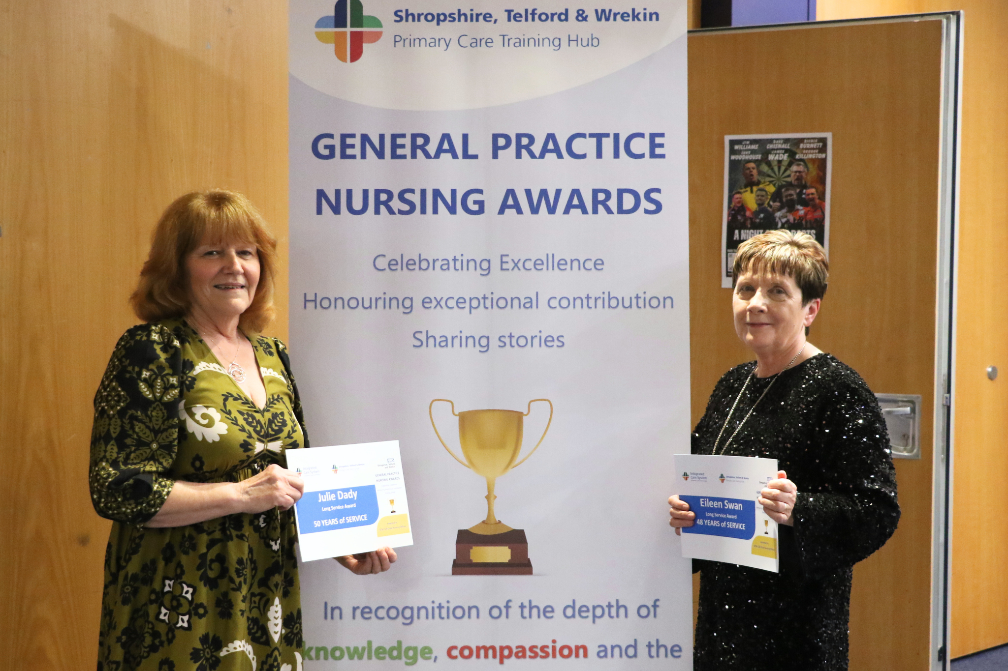 Two women stand with their certificates in front of a sign saying General Practice Nursing Awards